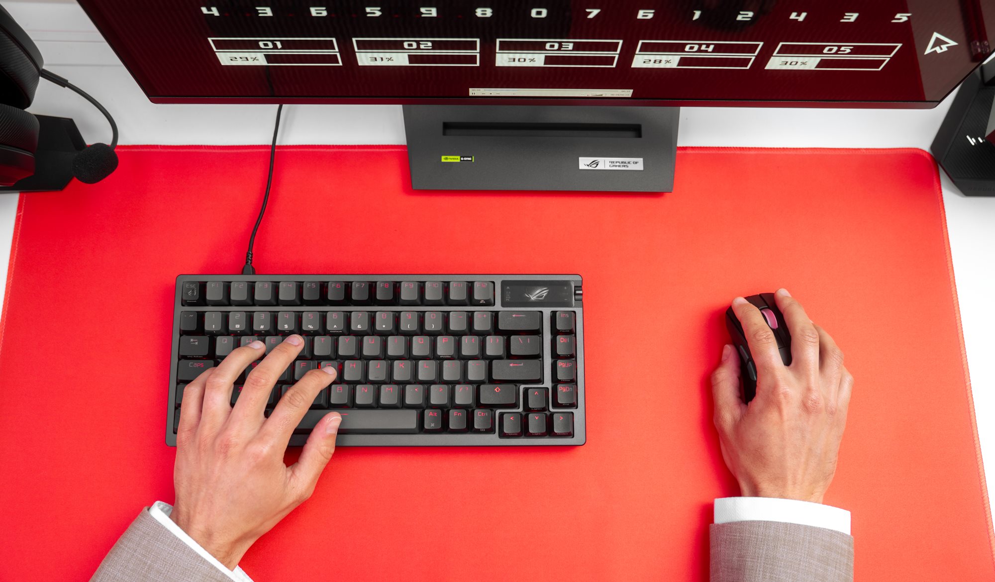 A top down view of a mouse and keyboard at an office desk, with a man's hands on each
