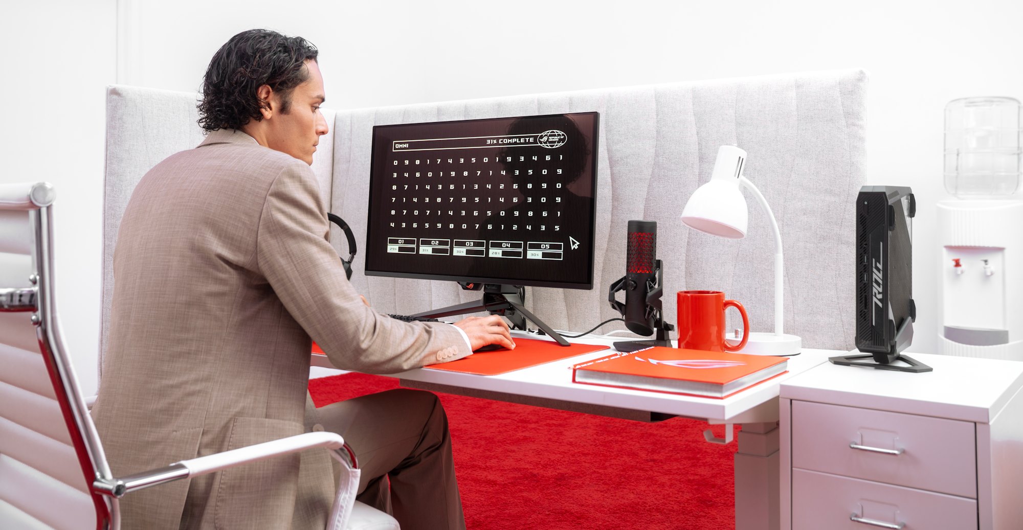 A young man in an office cubicle does some sorting using his ROG NUC mini PC